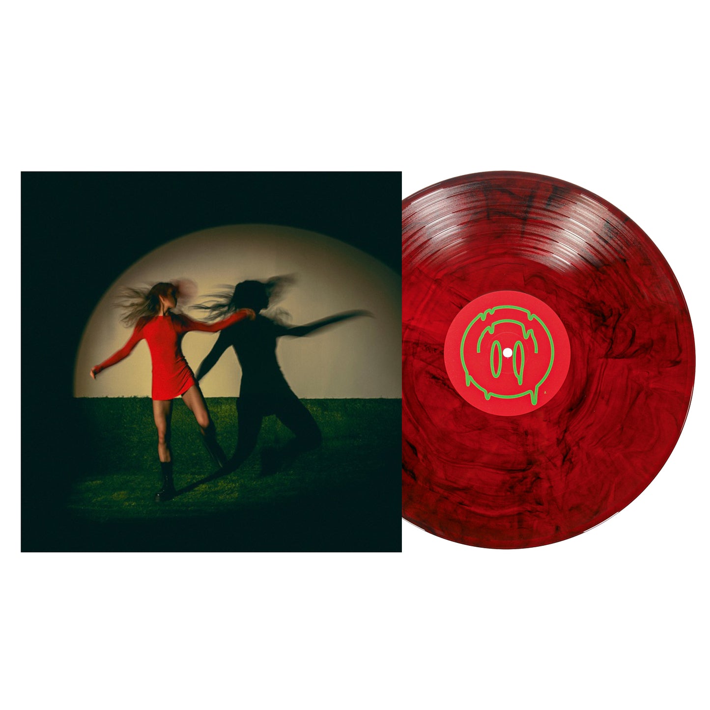 A Black & Red Galaxy Vinyl by Taylor Acorn with a green and pink center label sits next to an album cover showing two women in red dresses and black boots dancing, their dramatic shadows on the wall behind them.