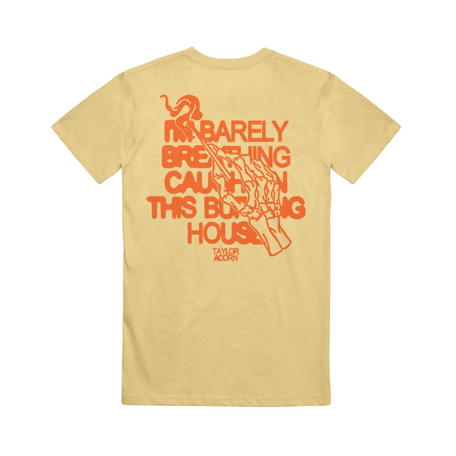 A yellow Taylor Acorn Comfort Colors tee featuring red text on the back: “I’M BARELY BREATHING CAUGHT IN THIS BURNING HOUSE,” with a red skeletal hand holding a match above the brand name.
