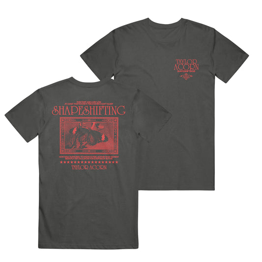 Black Comfort Colors t-shirt by Taylor Acorn featuring red text and graphics. Small Taylor Acorn logo on the front left chest; back displays bold Shapeshifting text, a curled-up figure, and additional Taylor Acorn branding.